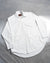 A white, long-sleeved, button-up shirt laid out flat on a surface.
